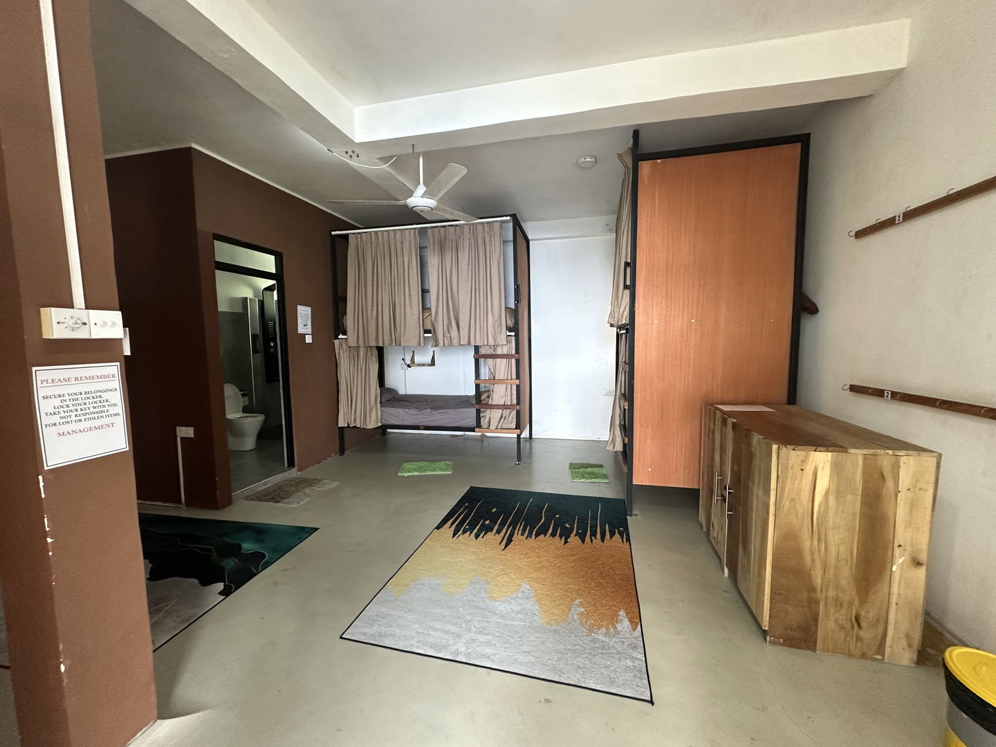 A six-bed dormitory with three sets of bunks and a ceiling fan.
