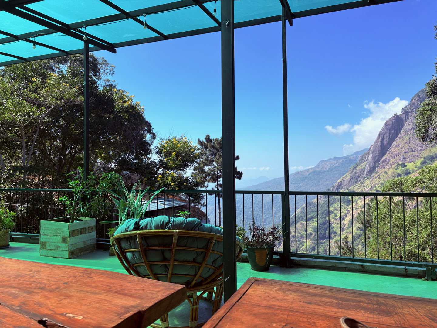 A hanging rattan egg chair on the terrace, facing the valley.